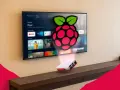 Un Raspberry Pi 3 con logo Raspberry Pi proietta un'interfaccia Android TV su uno schermo.
