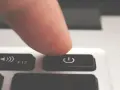 Dito, un dito preme il tasto di accensione/spegnimento per forzare lo spegnimento del PC.