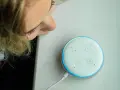 La ragazza si china per chiedere ad Alexa perché è rossa, ma la luce è blu.