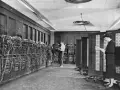 Il computer ENIAC, un gigante di cavi e pannelli, con due persone che lavorano al suo interno.