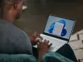 Uomo che usa un laptop con Windows 11. Potrebbe cercare come velocizzare Windows 11 con Regedit.