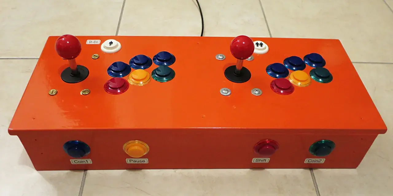 Joystick arcade arancione per retropie su pc, con pulsanti colorati e levette rosse.