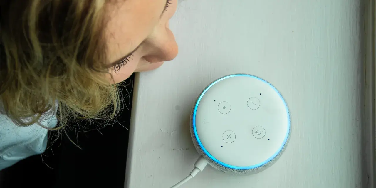 La ragazza si china per chiedere ad Alexa perché è rossa, ma la luce è blu.