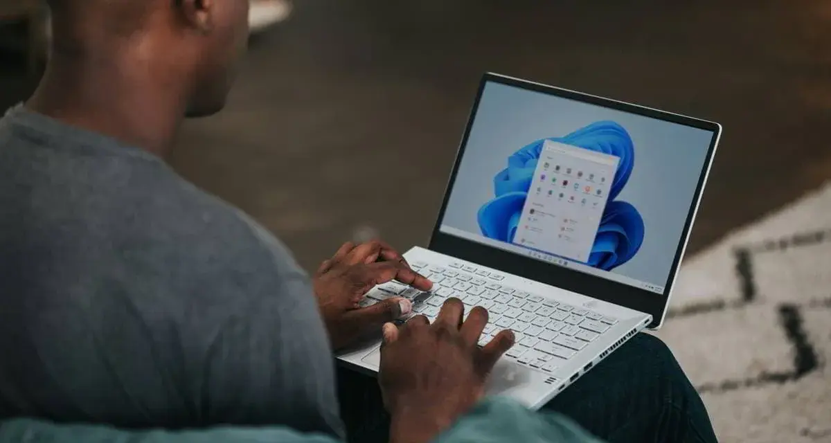 Uomo che usa un laptop con Windows 11. Potrebbe cercare come velocizzare Windows 11 con Regedit.