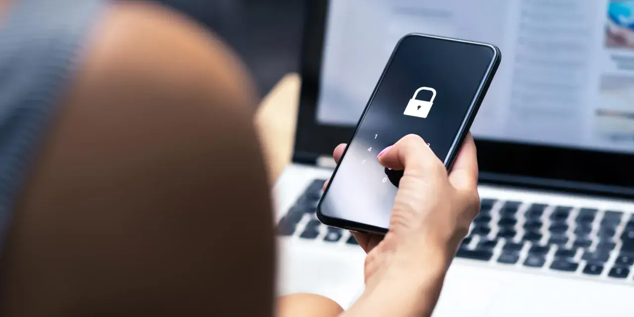 Mano che inserisce il codice per trovare telefono perso. Schermo bloccato con lucchetto.