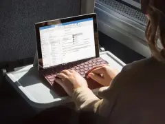 Donna lavora su un Surface con tastiera rossa, forse per disattivare modalità s windows 10.