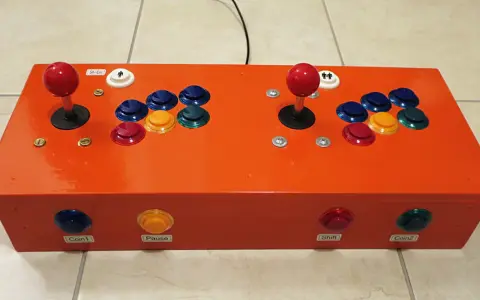 Joystick arcade arancione per retropie su pc, con pulsanti colorati e levette rosse.