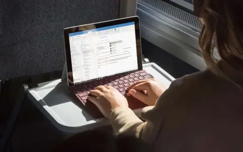Donna lavora su un Surface con tastiera rossa, forse per disattivare modalità s windows 10.