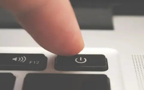 Dito, un dito preme il tasto di accensione/spegnimento per forzare lo spegnimento del PC.