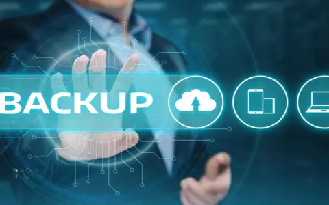 Un uomo tocca la parola "BACKUP" su uno schermo futuristico, con icone di cloud, smartphone e laptop.