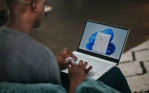Uomo che usa un laptop con Windows 11. Potrebbe cercare come velocizzare Windows 11 con Regedit.