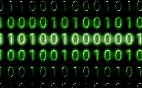 Sequenze di zeri e uno verdi brillano su sfondo nero. Il codice binario, che rappresenta il mb significato, scorre in righe.