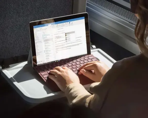 Donna lavora su un Surface con tastiera rossa, forse per disattivare modalità s windows 10.