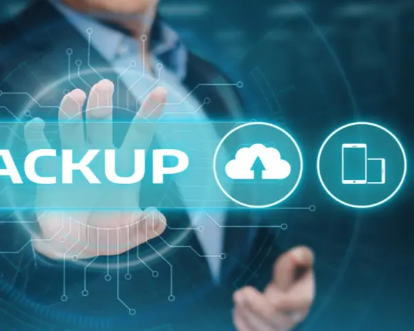Un uomo tocca la parola "BACKUP" su uno schermo futuristico, con icone di cloud, smartphone e laptop.