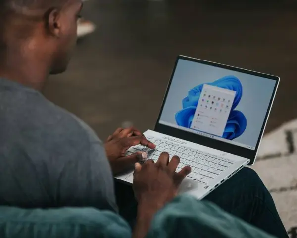 Uomo che usa un laptop con Windows 11. Potrebbe cercare come velocizzare Windows 11 con Regedit.