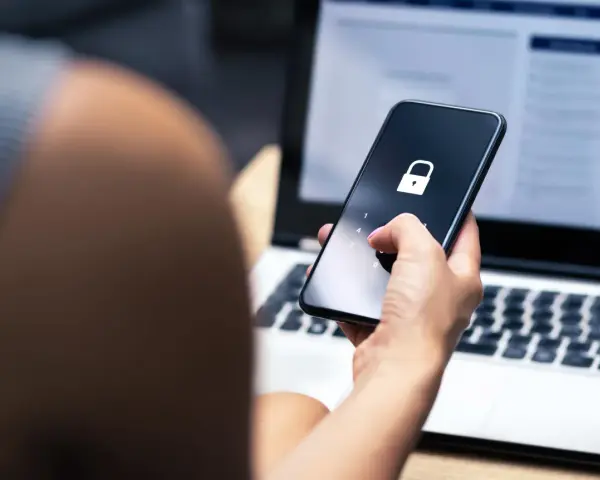Mano che inserisce il codice per trovare telefono perso. Schermo bloccato con lucchetto.