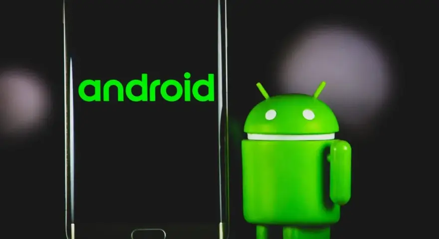 Un robot Android verde accanto a uno smartphone con il logo Android. La sincronizzazione automatica Android è fondamentale per mantenere i dati aggiornati.