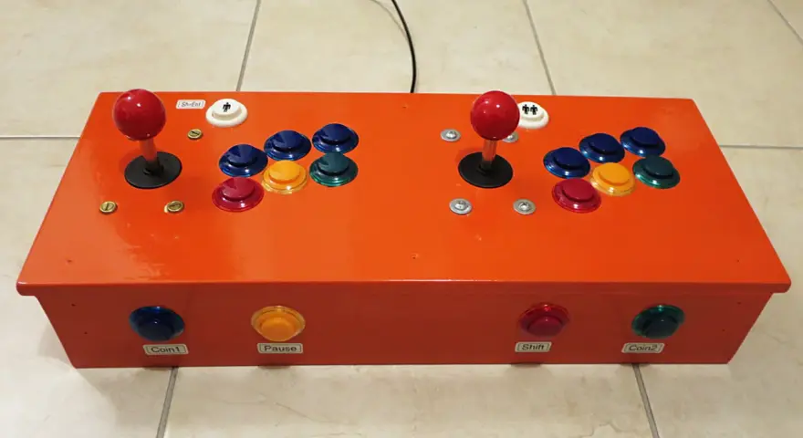 Joystick arcade arancione per retropie su pc, con pulsanti colorati e levette rosse.