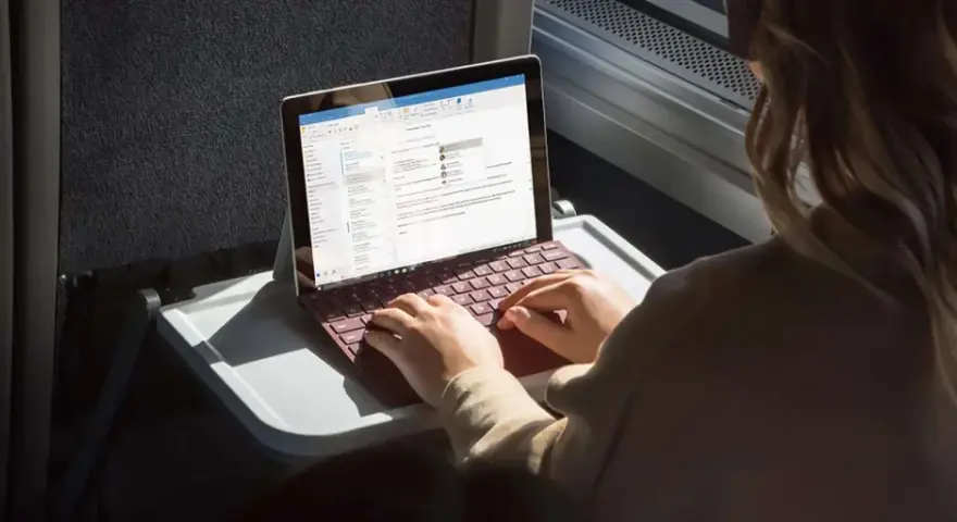 Donna lavora su un Surface con tastiera rossa, forse per disattivare modalità s windows 10.
