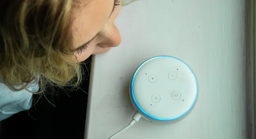 La ragazza si china per chiedere ad Alexa perché è rossa, ma la luce è blu.