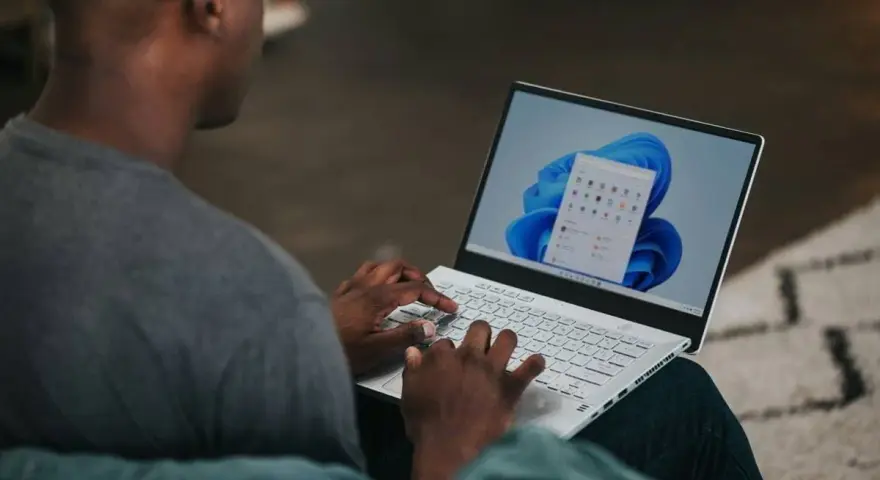 Uomo che usa un laptop con Windows 11. Potrebbe cercare come velocizzare Windows 11 con Regedit.