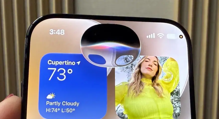 Schermo iPhone con widget meteo e foto. La Dynamic Island mostra un'onda colorata, forse perché Siri non risponde.