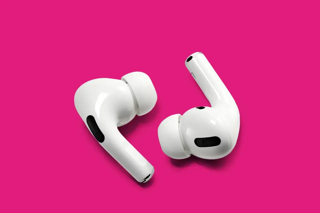 Auricolari bianchi su sfondo fucsia. Scopri perché le cuffie bluetooth non si collegano e come risolvere il problema.