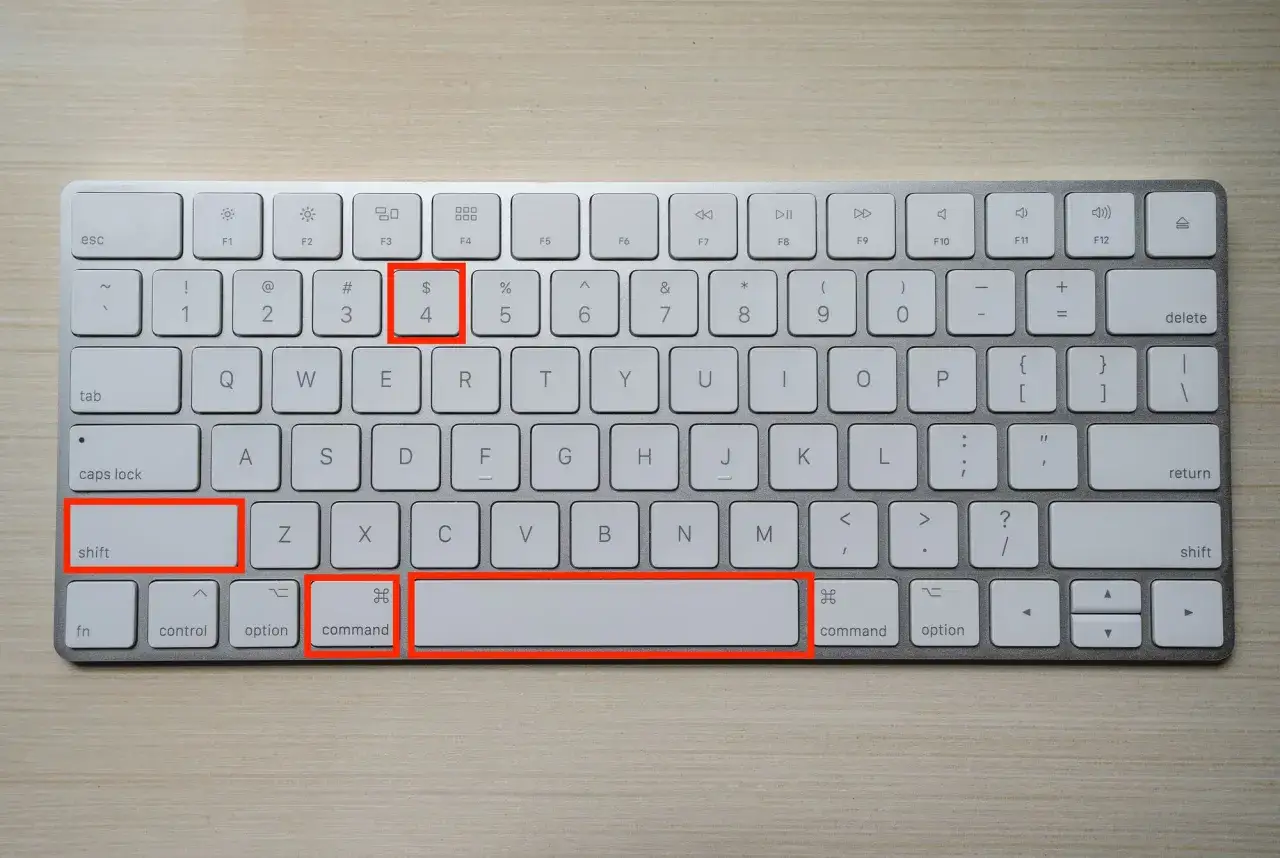 Tastiera Mac con tasti evidenziati: Shift, Command e il tasto con il simbolo del dollaro ($) e il numero 4.