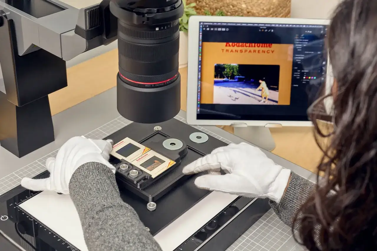 Un tecnico usa un sistema di scanner per digitalizzare vecchie diapositive Kodachrome, mostrando cos'è un processo di archiviazione digitale.