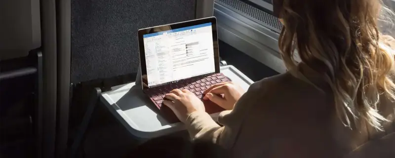 Donna lavora su un Surface con tastiera rossa, forse per disattivare modalità s windows 10.